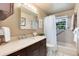 Bathroom featuring a brown vanity, a white shower curtain, and a window over tub at 6666 S Pennsylvania St, Centennial, CO 80121