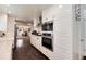 Modern kitchen with stainless steel appliances and white cabinetry flowing into the living space at 6666 S Pennsylvania St, Centennial, CO 80121