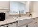 Close-up of kitchen sink featuring modern fixtures, bright window, and white subway tile backsplash at 6666 S Pennsylvania St, Centennial, CO 80121