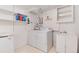 Bright laundry room with washer, dryer, shelving, utility sink, and extra storage at 6666 S Pennsylvania St, Centennial, CO 80121