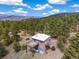 A well-maintained brick home featuring a deck and lush green surrounding, nestled in a green landscape at 77 Krestview Ln, Golden, CO 80401