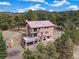 Unique stone house with a metal roof surrounded by forest and featuring multiple decks at 77 Krestview Ln, Golden, CO 80401