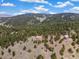 This stone home is set amongst a forest of trees with a vista of distant rolling mountains at 77 Krestview Ln, Golden, CO 80401