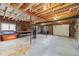 Spacious basement with unfinished ceiling, concrete floor, wood stove and garage door at 77 Krestview Ln, Golden, CO 80401