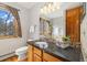 The bathroom features granite countertops, a framed mirror, and a beautiful view from the window at 77 Krestview Ln, Golden, CO 80401