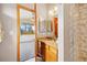 This bathroom features a granite countertop, wood cabinetry, and a shower with tile surround at 77 Krestview Ln, Golden, CO 80401