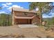 Charming stone house with a metal roof, a two-car garage, and wooden fence at 77 Krestview Ln, Golden, CO 80401