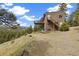 Exterior shot of the house showcasing the back porch and forest views at 77 Krestview Ln, Golden, CO 80401