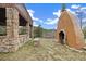 Exterior shot of a Southwestern-style outdoor fireplace and seating area overlooking the woods at 77 Krestview Ln, Golden, CO 80401
