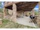 Stone outdoor patio with grill, picnic table, and wood beam ceiling for outdoor enjoyment at 77 Krestview Ln, Golden, CO 80401