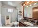 Bathroom features a granite-topped vanity, frosted glass shower doors, and open shelving at 2695 S Ames Way # 1, Lakewood, CO 80227