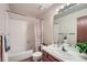 Bathroom features a shower-tub combo, vanity and a large mirror providing ample space at 2695 S Ames Way # 1, Lakewood, CO 80227