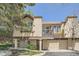 Inviting townhome with a tan exterior, balcony, mature trees, and a two-car attached garage at 2695 S Ames Way # 1, Lakewood, CO 80227