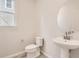 Clean bathroom with pedestal sink, toilet and oval mirror at 14083 Deertrack Ln, Parker, CO 80134