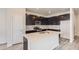 Modern kitchen with dark cabinetry, quartz countertops, and stainless steel appliances at 14083 Deertrack Ln, Parker, CO 80134