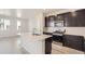 Modern kitchen with dark cabinetry, quartz countertops, and stainless steel appliances at 14083 Deertrack Ln, Parker, CO 80134