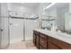 Bathroom with double vanity, shower, and neutral tile at 12432 Meadowlark Ln, Broomfield, CO 80021