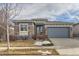 House exterior features stone and siding accents, a two-car garage, and a manicured lawn at 12432 Meadowlark Ln, Broomfield, CO 80021