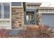 Front entrance with stonework, a glass door, and a wooden planter at 12432 Meadowlark Ln, Broomfield, CO 80021