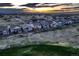 A captivating view of homes in a quiet neighborhood, framed by distant mountains and a dramatic sunset at 15788 Valentia St, Thornton, CO 80602