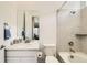 Bright bathroom featuring a shower-tub combo, a toilet, and a vanity with a sink and a mirror at 15788 Valentia St, Thornton, CO 80602