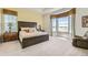 Inviting bedroom featuring neutral tones, plush carpeting, and a large window with scenic views at 15788 Valentia St, Thornton, CO 80602