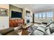 Comfortable living room featuring a fireplace, hardwood flooring and large windows at 15788 Valentia St, Thornton, CO 80602