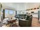 Open concept living room features lots of natural light, hardwood flooring, and comfortable seating at 15788 Valentia St, Thornton, CO 80602