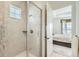 Modern shower with tiled walls, glass door, and convenient in-shower shelving at 15788 Valentia St, Thornton, CO 80602