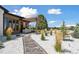 Landscaped backyard with stone pathway, pergola, outdoor seating, and lush greenery at 6915 Tremolite Dr, Castle Rock, CO 80108