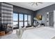 Modern bedroom featuring a luxury king bed, a gray accent wall, and an oversized sliding glass door at 6915 Tremolite Dr, Castle Rock, CO 80108