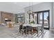 Open-concept dining area with modern chandelier, patio doors, and seamless flow into the living room with fireplace at 6915 Tremolite Dr, Castle Rock, CO 80108