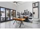 Spacious home office featuring modern desk, statement wall, and access to the outdoor living space at 6915 Tremolite Dr, Castle Rock, CO 80108