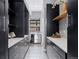 Walk-in pantry featuring white countertops, black cabinets, and built-in shelving for optimal organization at 6915 Tremolite Dr, Castle Rock, CO 80108