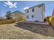 Backyard view with a white two-story home, concrete patio, and a wooden fence at 15047 E 50Th Dr, Denver, CO 80239