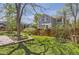 Grassy backyard with a wood fence, mature trees, landscaping and patio in a lush setting at 15976 Quarry Hill Dr, Parker, CO 80134
