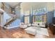 Elegant living room with high ceilings, large windows, and an open staircase, creating a bright and inviting space at 15976 Quarry Hill Dr, Parker, CO 80134