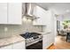 Modern kitchen with stainless steel gas range, white cabinets, beautiful countertops and hardwood flooring at 1947 King St, Denver, CO 80204
