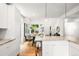 A modern kitchen with a large island featuring gorgeous countertops and white cabinets, open to the living area at 1947 King St, Denver, CO 80204