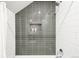 Modern tiled shower featuring gray accent tiles and built-in shelving for toiletries at 1947 King St, Denver, CO 80204