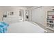 Well-lit bedroom featuring a walk-in closet, adjacent bathroom, and comfortable white bed at 806 Cabot Dr, Erie, CO 80516