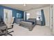 Well-lit bedroom with desk area, blue accent wall, and coordinated gray furniture at 806 Cabot Dr, Erie, CO 80516
