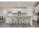 Bright kitchen boasts white cabinets, granite counters, stainless appliances, and a breakfast bar with seating at 806 Cabot Dr, Erie, CO 80516