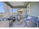 Covered patio is furnished with comfortable seating, a barbecue grill, and decorative drapes at 806 Cabot Dr, Erie, CO 80516