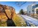 Snowy backyard with lattice fence and grassy area at 7684 Mule Deer Pl, Littleton, CO 80125