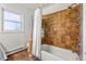Bathroom with tan tile shower/tub combo and a bright window at 5601 E Colorado Ave, Denver, CO 80224