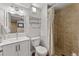 Well-lit bathroom featuring a tiled shower with a floral curtain, updated vanity, and a modern toilet at 5601 E Colorado Ave, Denver, CO 80224