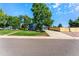 View of the home's garage and spacious driveway with a modern wooden fence for added privacy at 5601 E Colorado Ave, Denver, CO 80224