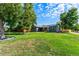 Landscaped front yard and charming single-story home with solar panels in a lush green setting at 5601 E Colorado Ave, Denver, CO 80224