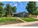 Well-maintained front yard and gray single-story home with a sidewalk to the front door at 5601 E Colorado Ave, Denver, CO 80224